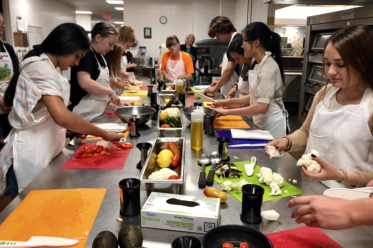 After a knife-skills crash course, attendees chop vegetables for their dinner entrées